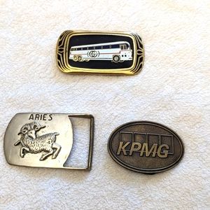 3 Belt Buckles. Zodiac sign Aries, gray Coach Bus and KPMG.